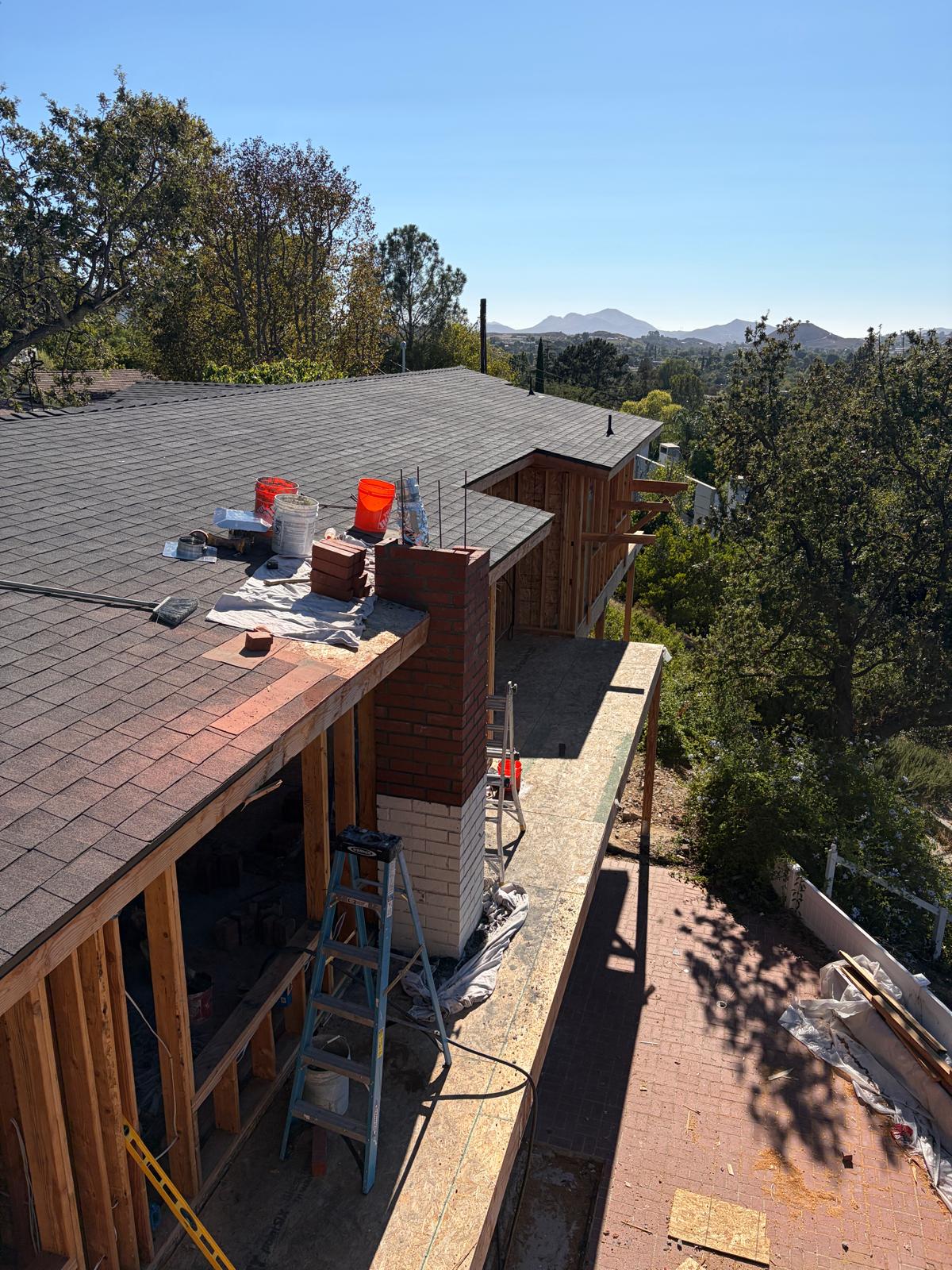 Brick chimney extending through a roofline during repair work